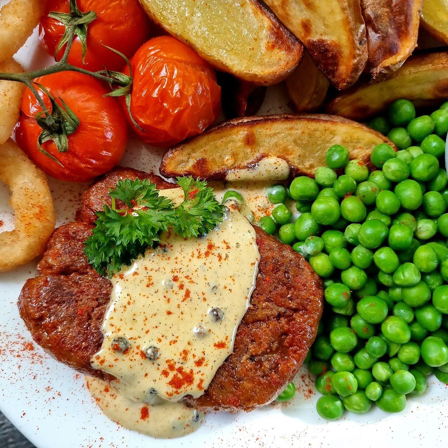 Steak with Peppercorn Sauce, Skins on Wedges, Grilled Vine Tomatoes & Peas
